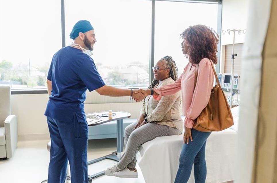 provider shaking hands with patient's family